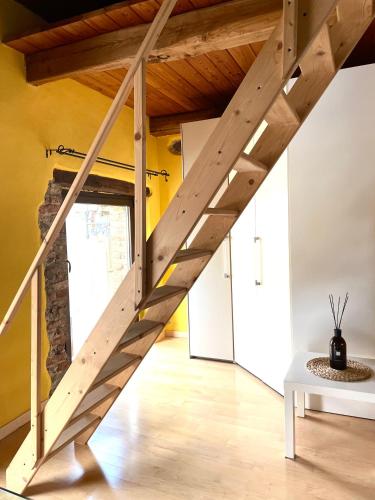 a staircase in a room with yellow walls and wooden ceilings at Il Fienile in Garessio
