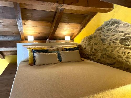 a bed in a room with a wooden ceiling at Il Fienile in Garessio
