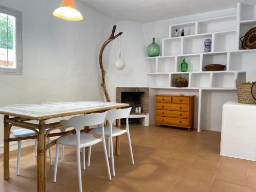 a dining room with a table and white chairs at Can Brilla in Sant Francesc Xavier