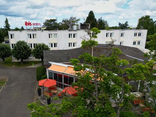 a white building with a red sign on top of it at ibis Chartres Ouest Luce in Chartres