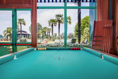a pool table in a room with palm trees at Royal Garden Assago Milano in Assago