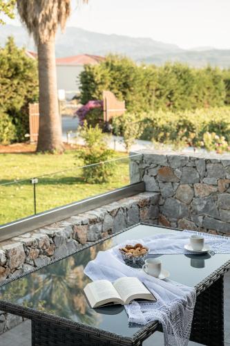 a table with a book and a plate of food on it at Villa Enny, 3 BD with Private Heated Pool in Ayiá