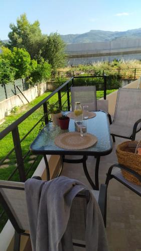 a table with a glass of wine on a balcony at Sunkissed and Seasalted House in Melission