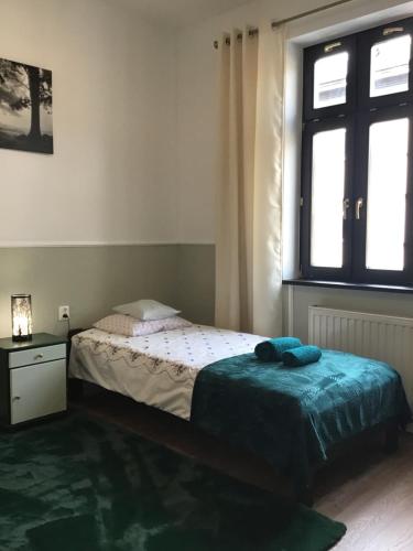 mała sypialnia z łóżkiem i oknem w obiekcie Goldengreen Apartment w Krakowie