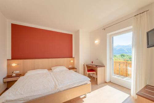 a bedroom with a bed and a large window at Sandhof in Termeno