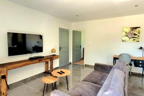 a living room with a couch and a flat screen tv at MAISON PLEIN-PIED DÉTENTE ASSUREE Clim-BBQ in Varetz