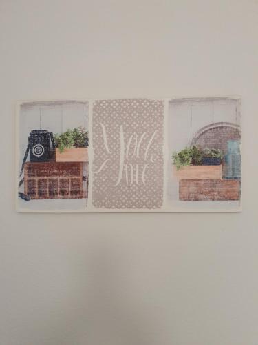 a picture of three windows with plants and a camera at Beira Mar Loft in Aveiro