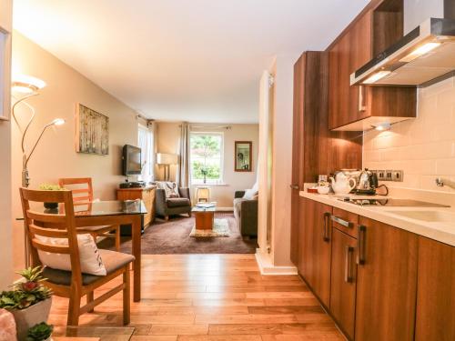a kitchen with a table and a living room at Cosy Corner in the Lakes in Penrith