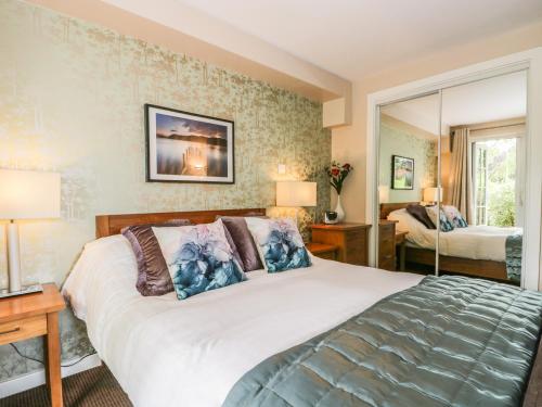 a bedroom with a large bed and a mirror at Cosy Corner in the Lakes in Penrith