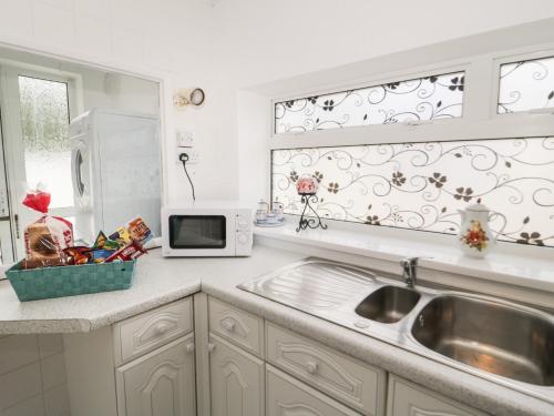 a kitchen with a sink and a microwave at Mountain Ash in Rhyl