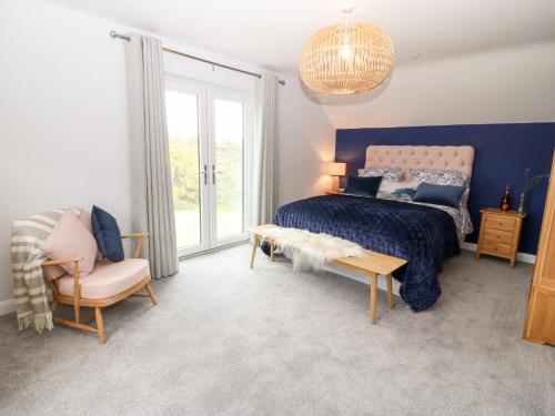 a bedroom with a bed and a chair at 11 Parc Delfryn in Brynteg