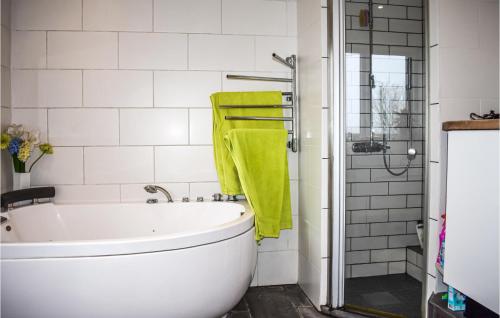 a bathroom with a white tub and a green towel at 3 Bedroom Beautiful Home In Köpingebro in Köpingebro