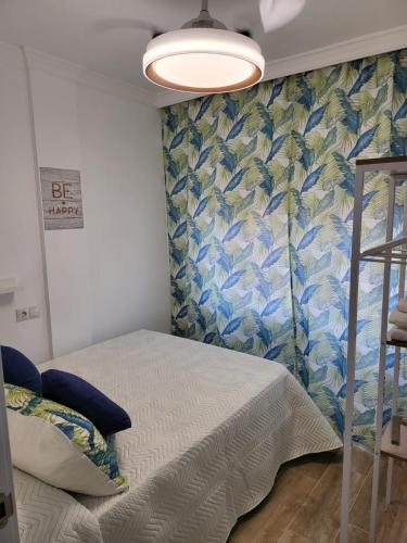 馬拉加的住宿－APARTAMENTO SH，一间卧室设有一张床和蓝白色的墙壁