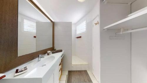 uma casa de banho branca com um lavatório e um espelho em Manganao Studio Supérieur em Saint-François