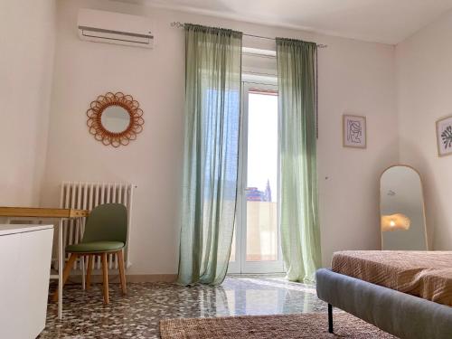 1 dormitorio con cama, mesa y ventana en La Vue est Belle - Puglia Mia Apartments en Monopoli