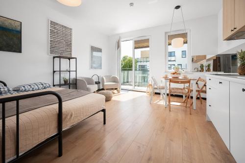 a bedroom with a bed and a kitchen with a table at Apartament TOLA in Puck