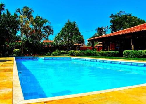 a large blue swimming pool in front of a house at Numa Boa HOSTEL Búzios in Búzios