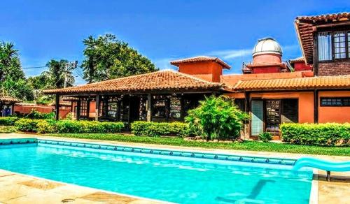 a house with a swimming pool in front of a building at Numa Boa HOSTEL Búzios in Búzios