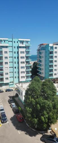 a parking lot with cars parked in front of tall buildings at Luna Rossa Sumerland in Mamaia