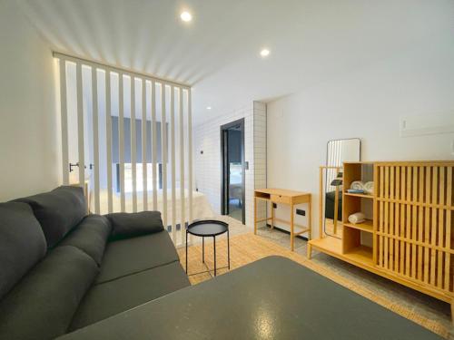 a living room with a couch and a bedroom at Apartamentos Mk77 León - LaHoz in León