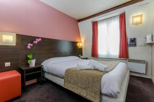 Letto o letti in una camera di Hotel Arc Paris Porte d'Orléans
