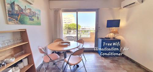 une salle à manger avec une table et des chaises et une fenêtre dans l'établissement Jolie Vue - La Loge, à Hyères