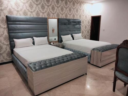 Säng eller sängar i ett rum på Grand Swiss Hotel&Apartment Lahore
