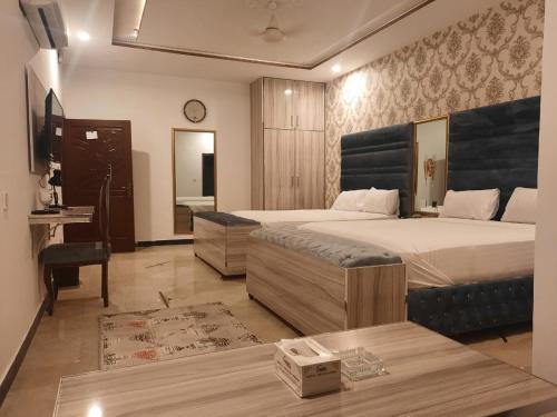 Säng eller sängar i ett rum på Grand Swiss Hotel&Apartment Lahore