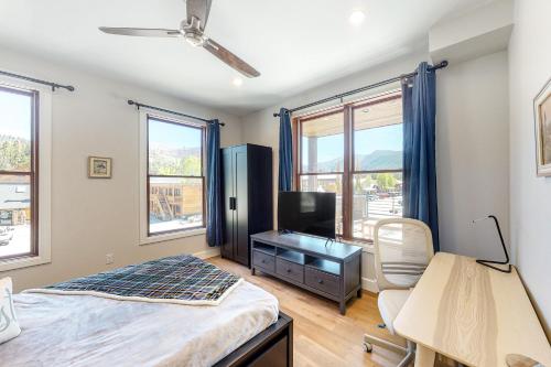 a bedroom with a bed and a desk and a tv at Brand New Boardwalk Getaway in Grand Lake