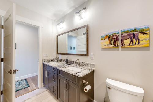 a bathroom with two sinks and a toilet and a mirror at Brand New Boardwalk Getaway in Grand Lake