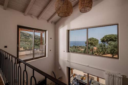 a staircase in a house with two windows at Cossoro Villas Zakynthos in Xirokástellon