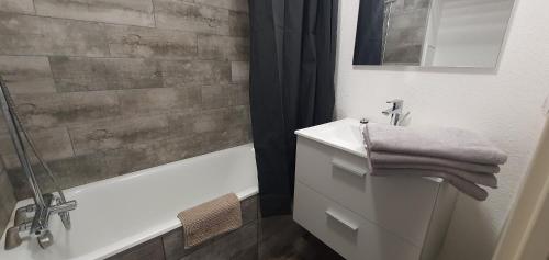 La salle de bains est pourvue d'un lavabo, d'une douche et d'une baignoire. dans l'établissement Jolie Vue - La Loge, à Hyères