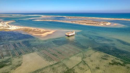 an island with a bus in the water at Ken Blacklock in Fuzeta