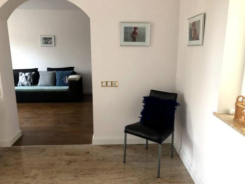 - une chaise noire dans le salon avec canapé dans l'établissement Giovanni’s Home, à Sfântu-Gheorghe