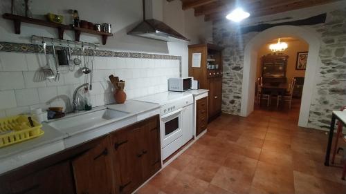 uma cozinha com um lavatório e um fogão forno superior em Casa Valle em Foz