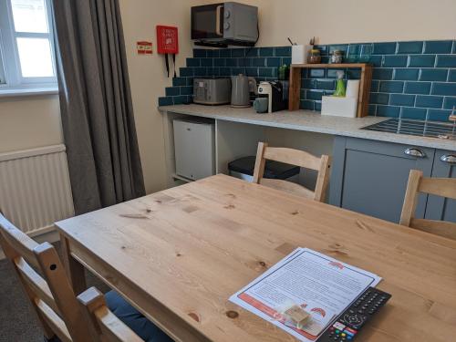 a table in a kitchen with a laptop on it at The Ramblers' Rest - Princetown in Princetown