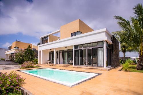 una casa con piscina frente a ella en Villa Fitz: Sunlit Beach Getaway w/ Pool + WIFI, en Belle Mare