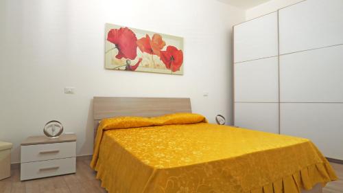 a bedroom with a bed with a yellow blanket on it at Casa Manni Taviano-Salento in Taviano