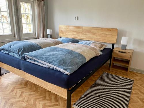 a bedroom with a large bed with a wooden headboard at Großes Ferienhaus an der Ostsee "Oldevighus" in Hohenkirchen