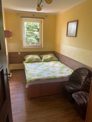 ein kleines Schlafzimmer mit einem Bett und einem Fenster in der Unterkunft Limba in Łeba