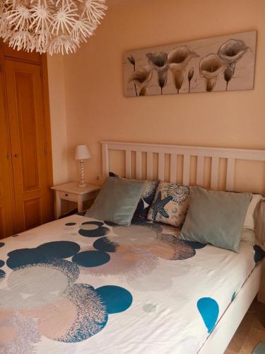 a bedroom with a bed with a blue and white blanket at Manilva Playa in Manilva