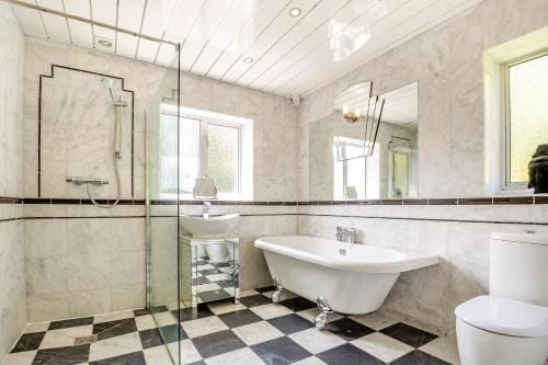 a bathroom with a sink and a tub and a toilet at The Art Deco House in Menai Bridge