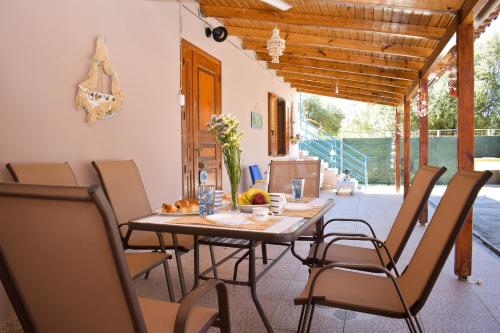 a dining room with a table and chairs at Malou Garden House Near The Beach in Glífa