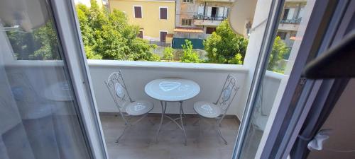 a balcony with a blue table and three chairs at Clausis in Parghelia
