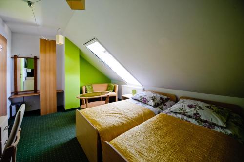 ein Hotelzimmer mit 2 Betten, einem Tisch und einem Stuhl in der Unterkunft Pokoje Gościnne Aga in Widuchowa