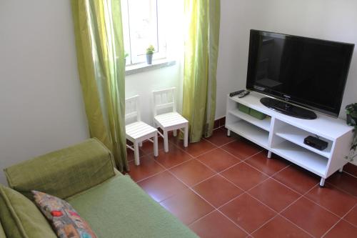 a living room with a couch and a flat screen tv at Casa do Chafariz in Vila Velha de Ródão