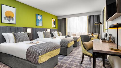 タラにあるプラザホテル タラトのベッド2台とデスクが備わるホテルルームです。