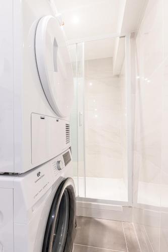 - un lave-linge dans une buanderie blanche avec un miroir dans l'établissement Le Loft Magnan - AC- Prés mer - WIFI - Confort et moderne - Supermarchés et Tram proches, à Nice