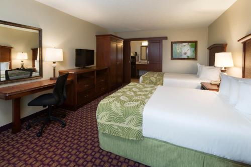 a hotel room with a bed and a desk and a computer at Rosen Inn at Pointe Orlando in Orlando