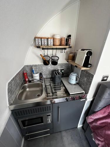a small kitchen with a sink and a stove at The Cozy Cub in Romsey